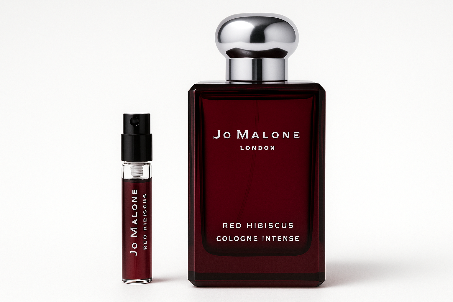 Muestra de Jo Malone Red Hibiscus Cologne Intense de 2 ml junto a una botella de perfume de 100 ml de Jo Malone Red Hibiscus Cologne Intense con escritura blanca sobre una botella de color rojo oscuro.