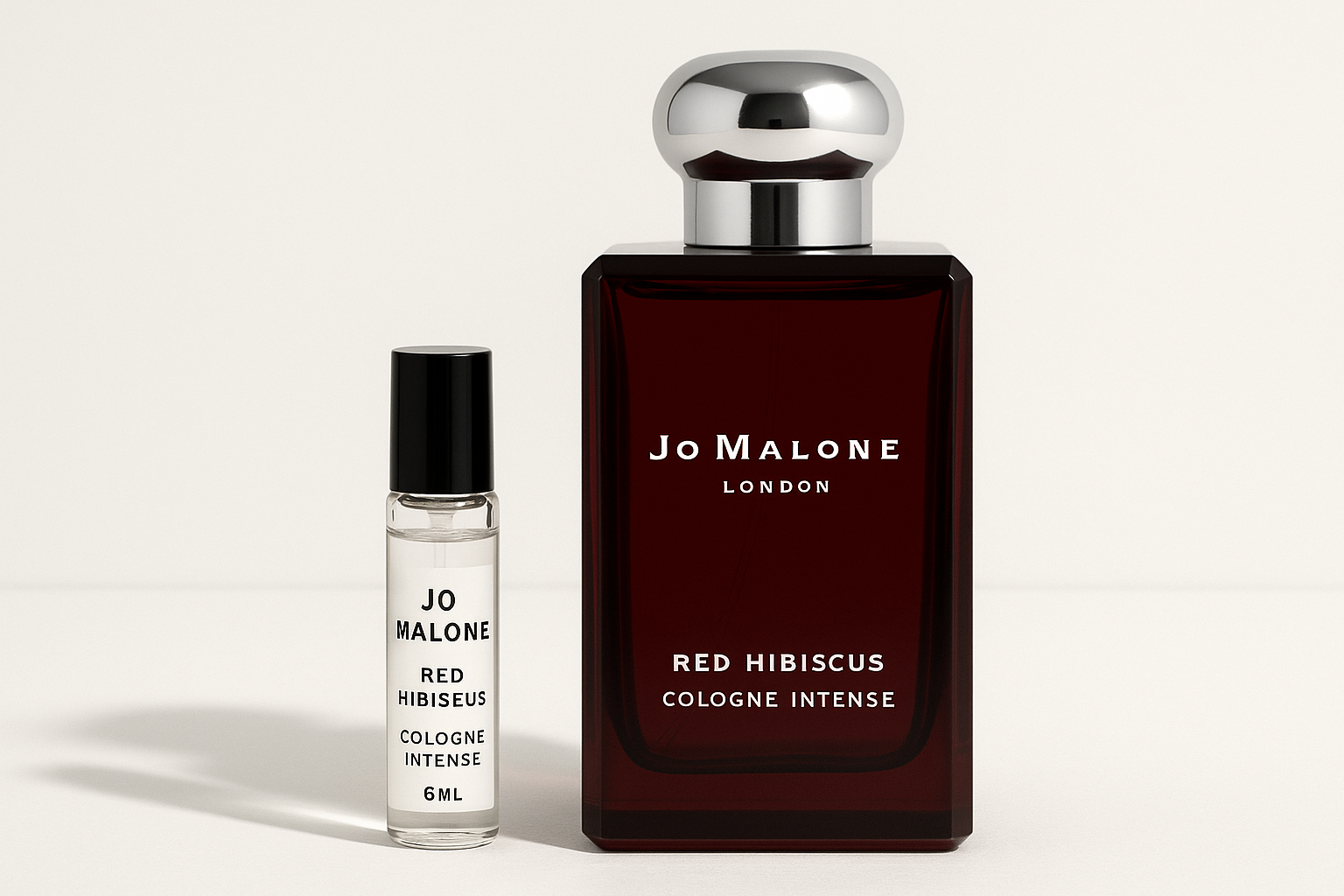 Muestra de Jo Malone Red Hibiscus Cologne Intense de 6 ml junto a un frasco de perfume de 100 ml de Jo Malone Red Hibiscus Cologne Intense con escritura blanca sobre un frasco rojo oscuro.